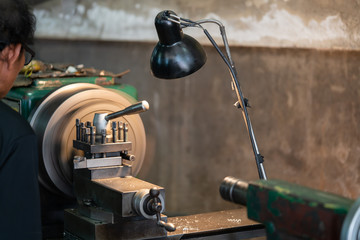 Professional machinist : man operating lathe grinding machine - metalworking industry concept.
Mechanical Engineering control lathe machine in factory.