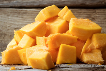 cut pieces of pumpkin on wooden background