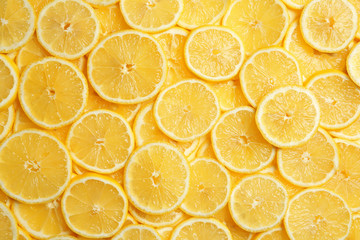 Slices of fresh juicy lemons as background, top view