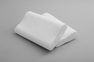 Clean soft orthopedic pillows on grey background