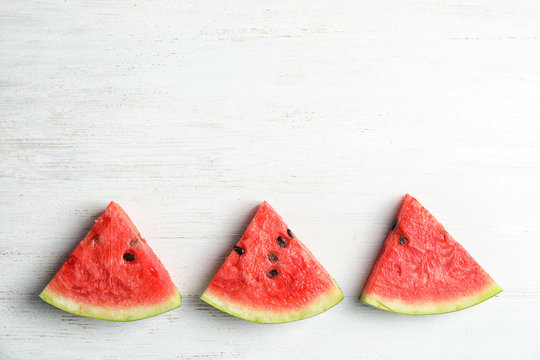 Flat lay composition with watermelon slices on white wooden background