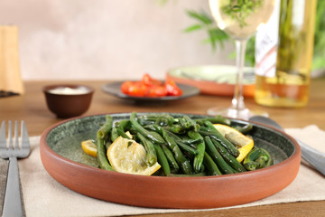 Delicious green beans with lemon served for dinner on table