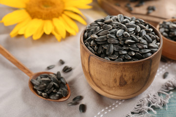 Bowl and spoon with sunflower seeds on table
