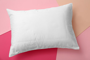 Soft bed pillow on color background, top view