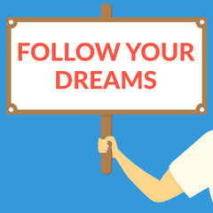 FOLLOW YOUR DREAMS. Hand holding wooden sign