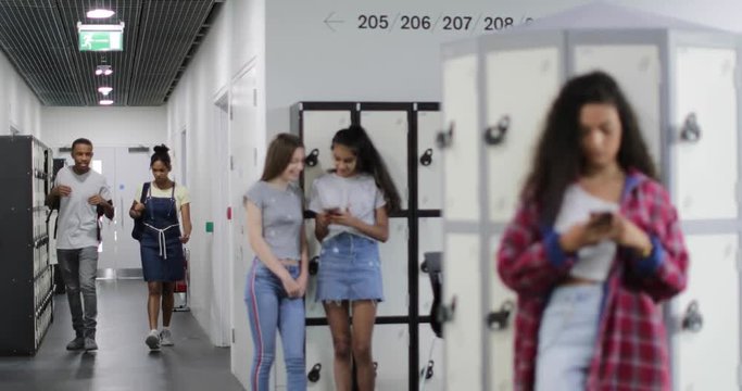 Students in high school corridor - Powered by Adobe