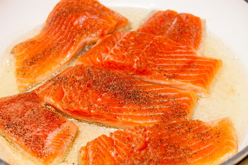 Pan frying red trout fillets, also known as arctic char