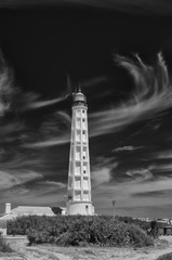 Biała latarnia na tle ciemnego nieba, ujęcie pionowe. Biało-czarny. © Aneta