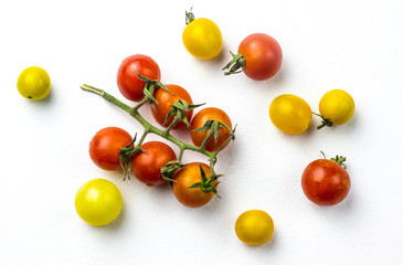 Obraz premium Red and yellow cherry tomatoes on a white background