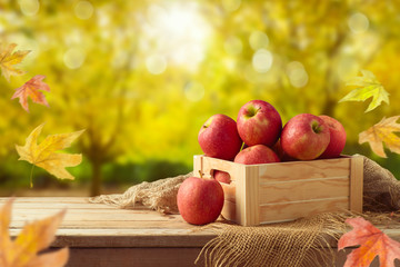 Red apples in wooden box on table