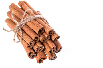 Heap of dry cinnamon sticks on white background