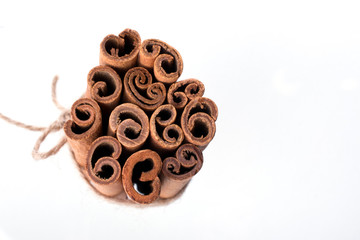 Heap of dry cinnamon sticks on white background