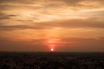 Sol rojo en el horizonte sobre la ciudad 