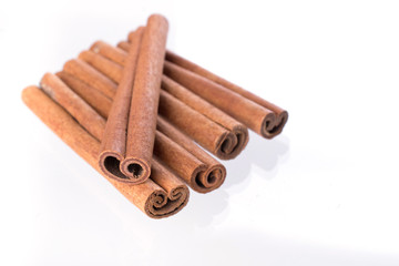 Heap of dry cinnamon sticks on white background