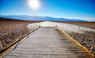 Wooden viewing platform at the Badwater Basin, the second-lowest point in the Western Hemisphere, at sunset, Death Valley National Park, California, USA.