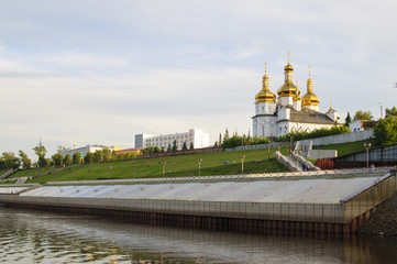 Tura River Embankment in Tyumen, Russia. Holy Trinity Monastery.