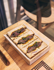 Japanese medium rare Wagyu sandwich served in wooden box. 