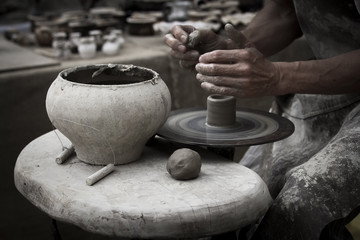 A raw clay pot in the hands of a potter. Workshop in the pottery workshop