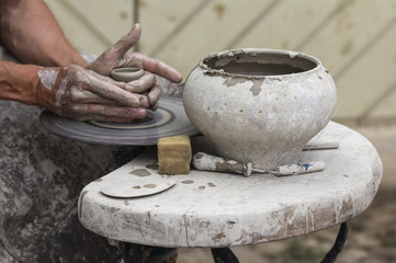 A raw clay pot in the hands of a potter. Workshop in the pottery workshop