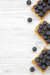 Vegan toasts with peanut butter, blueberries and chia seeds on a white wooden table, top view. Healthy eating. Flat lay, from above. Space for text.