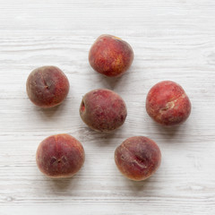 Fresh ripe peaches on white wooden background, top view. From above, overhead, flat lay.