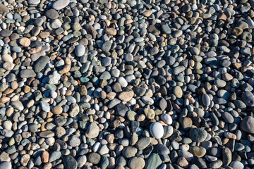 Background of small stones lying on the beach.