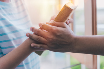 Obraz premium Women praying to the holy scripture. Her hand holding hands Bible pray in church for the faith and spiritual concept of religion.