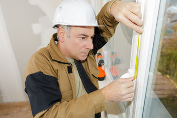 double glazing installer measuring the window