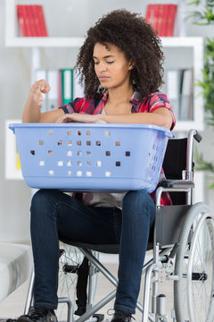 young woman on the wheelchair with laundry basket