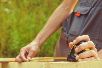 the worker makes measurements with a tape measure