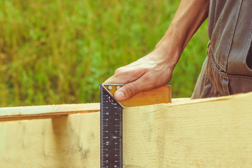 the worker makes measurements with a tape measure