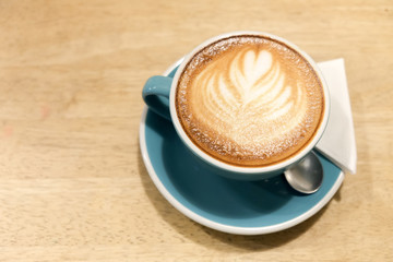 A cup of coffee Latte art green glass on wood table
