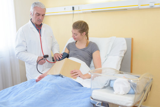 doctor checking blood pressure of the female patient