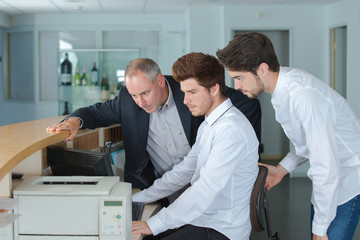 young men registering guest on arrival in hotel