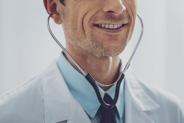 Be proud. Attractive man feeling happiness and wearing medical uniform