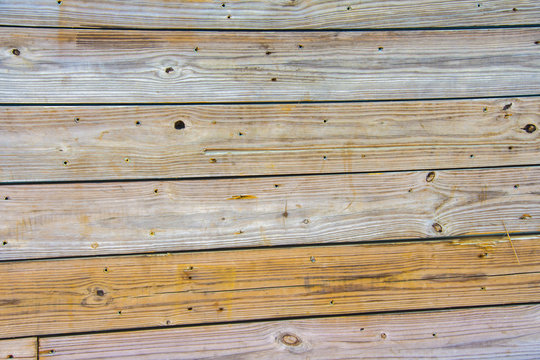 Weathered Wood Planks form a placard wall, marked by the test of time,