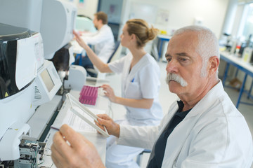 senior male laboratory worker using equipment