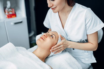 Obraz na płótnie Canvas Face massage to female patient, cosmetology clinic