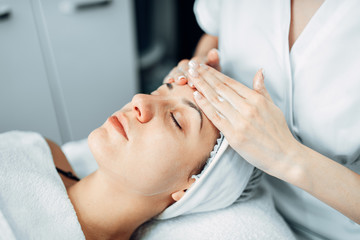 Fototapeta na wymiar Face massage to female patient, cosmetology clinic