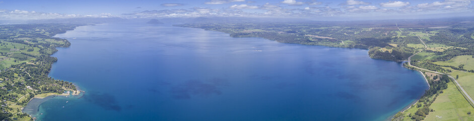 Rupanco Lake, one of the Great lakes in Southern Chile with an amazing aerial view from the drone over Osorno and Puntiagudo Volcanoes surrounded by the water and the trees during the sunset, Chile