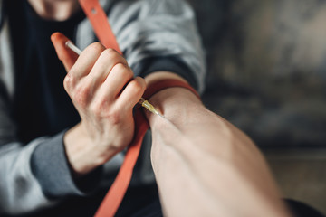 Male junkie with syringe doing an injection dose
