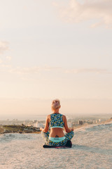 Fototapeta premium woman meditating in lotus position on the mountainside, yoga, sea view
