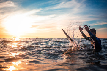 Sun surfer. A man is walking with a surf in his hands across the sea shore.