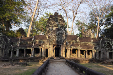 Obraz premium Ancient ruins of Ta Prohm temple in Angkor Wat complex, Cambodia. Decorated entrance with stone bas-relief.