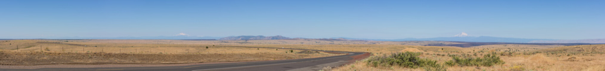 Fototapeta na wymiar Panorama of central Oregon plains with road 101 and the Cascade mountain range in the horizon.