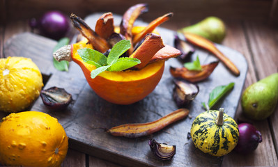 autumn fruit. pumpkin and onions baked with honey. on a brown background