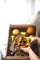 pumpkin baked with honey. autumn fruit. pumpkin woman hands. dinner on a wooden tray,