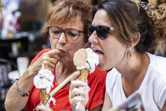 Mother and daughter eating an ice cream on the street