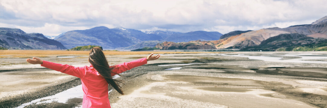 Iceland travel lifestyle freedom tourist woman in nature wanderlust with open arms feeling happy and carefree, panoramic banner. Adventure in nature panorama.