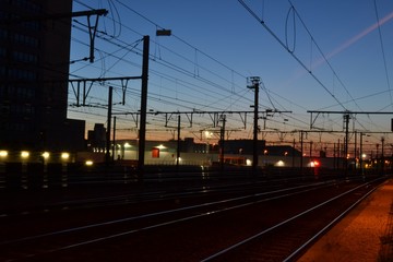 Fototapeta na wymiar Nighttime photograph of railway tracks, taken shortly after sundown in Leuven, Belgium.
